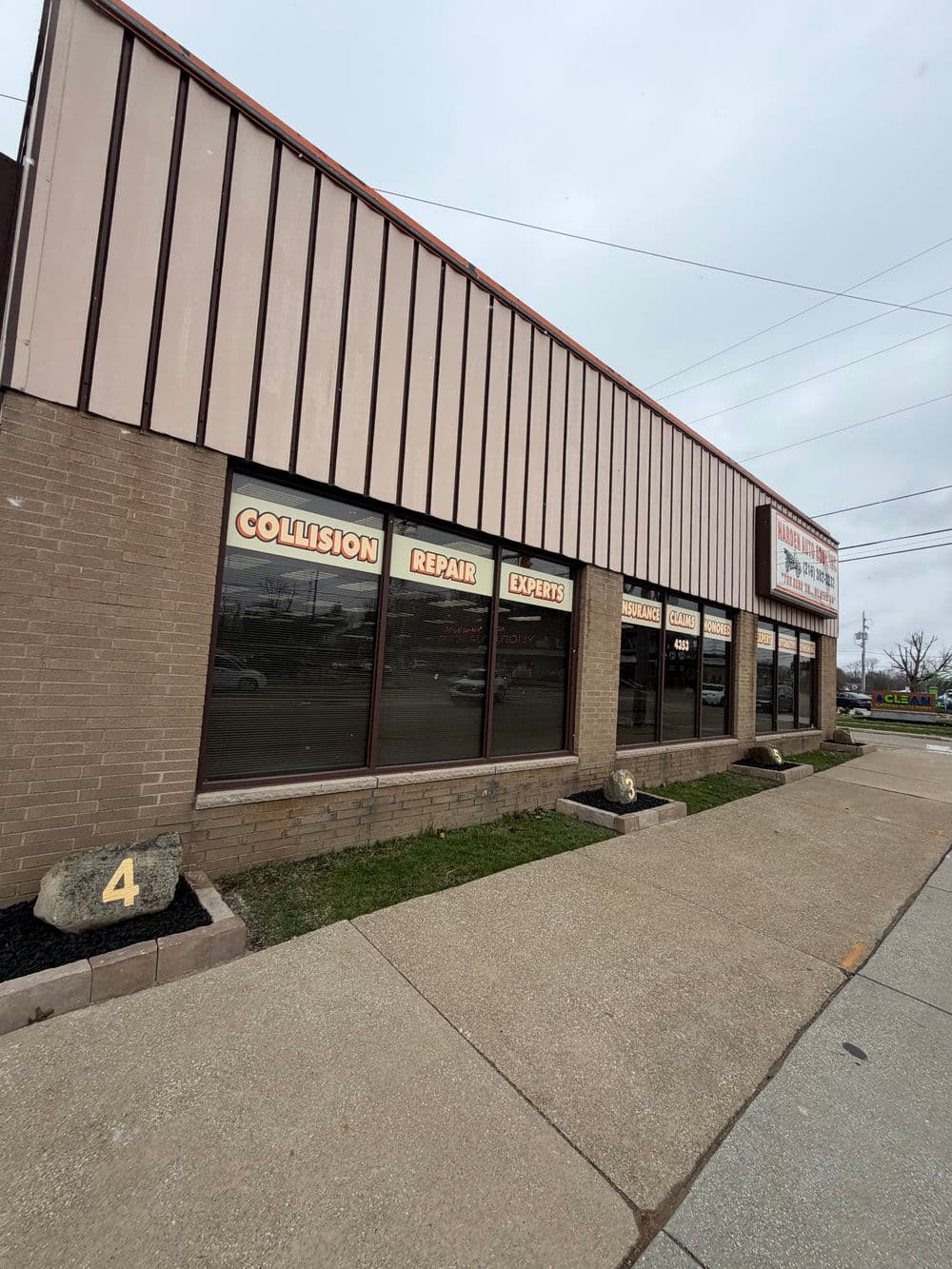 Collision repair shop exterior with prominent "Collision Repair Experts" signage.